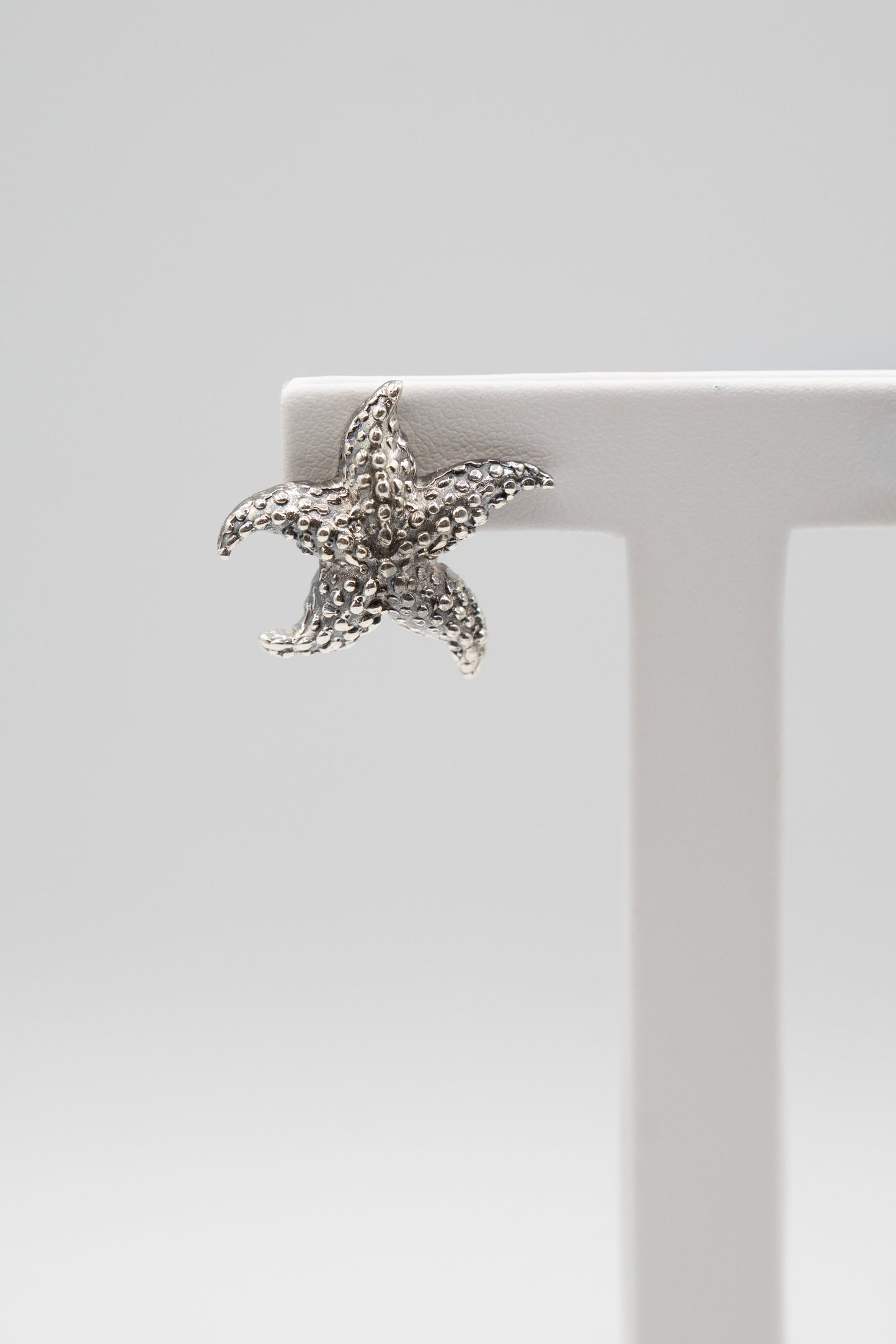 Dettaglio ravvicinato dell’orecchino Marea Stellata in argento con lavorazione materica